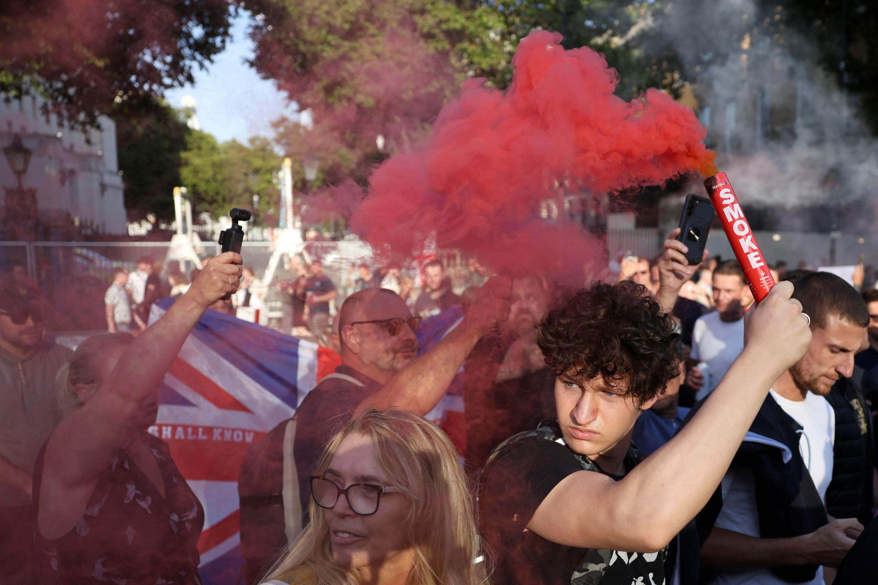 Um manifestante segura um sinalizador durante um protesto contra a imigração ilegal