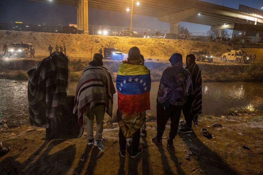 Tropas de la Guardia Nacional de Texas y la policía estatal impiden que migrantes de Venezuela ingresen a una zona de cruce popular a lo largo de la orilla del Río Bravo en El Paso, Texas, después de colocar alambre de concertina el 20 de diciembre de 2022, visto desde Ciudad Juárez, México. 