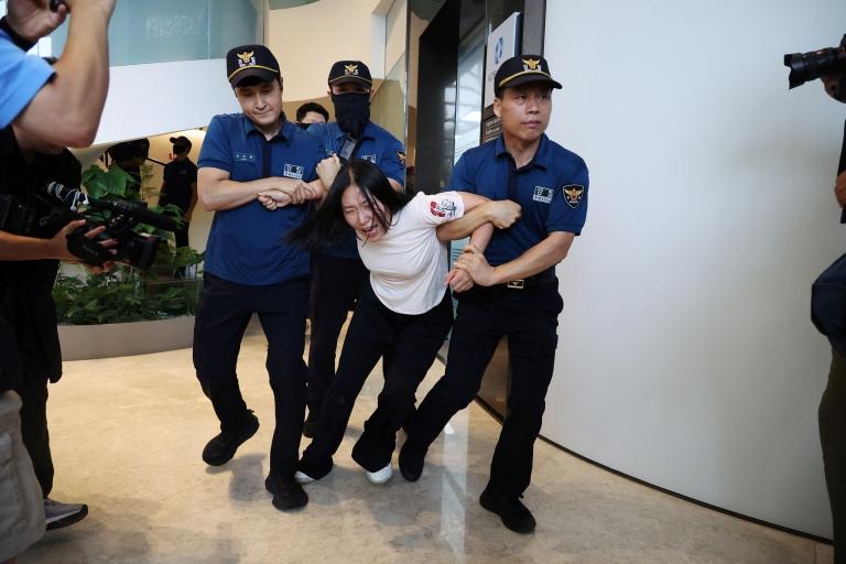 Seorang mahasiswi memaksa masuk ke Kedutaan Besar Jepang di Seoul, Korea Selatan, pada Kamis (24/8), guna memprotes pelepasan air bekas pembangkit listrik tenaga nuklir (PLTN) non-aktif Fukushima ke Samudra Pasifik. (Foto: Reuters)