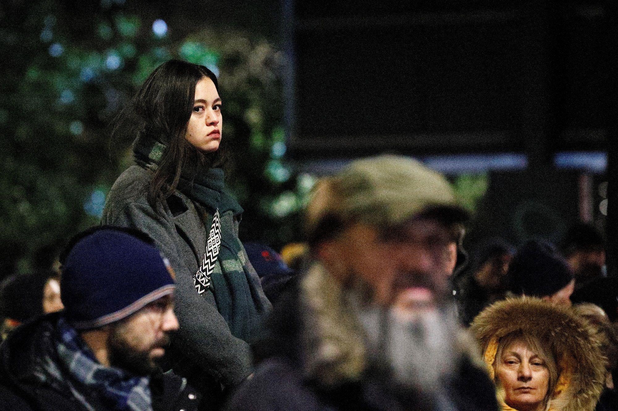 Devojka iznad mase ljudi na protestu, duge crne kose