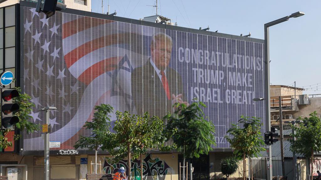 Billboard em Tel Aviv em 6 de novembro, parabenizando Donald Trump por sua vitória eleitoral. O outdoor retrata as bandeiras dos EUA e de Israel, Trump e as palavras: 