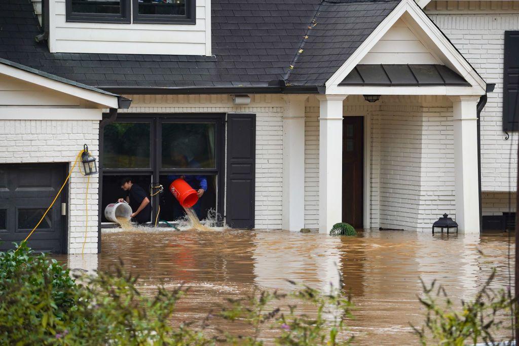 Dos personas sacan agua de una casa en Atlanta