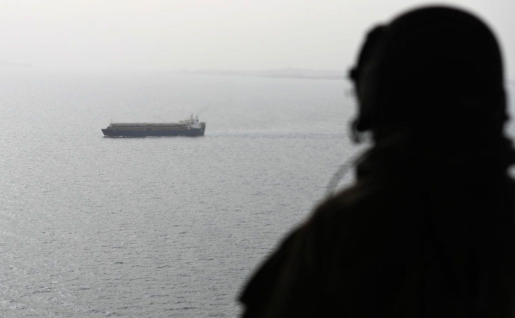 جنديا إماراتيا يراقب من طائرة عسكرية سفينة تعبر عبر مضيق باب المندب عام 2018