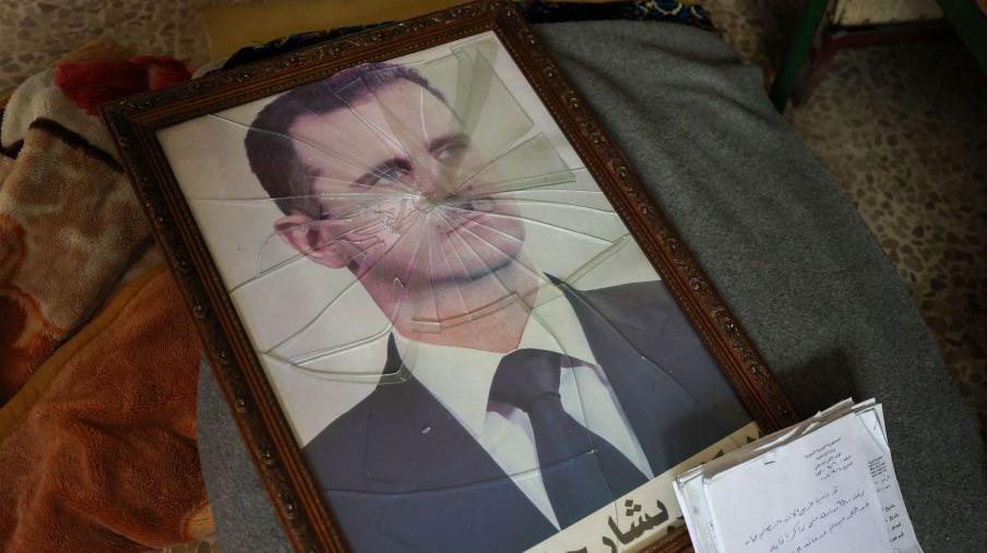 Un retrato roto y en el suelo de Bashar al Assad.