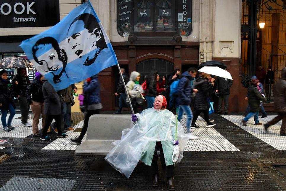 Una mujer durante una marcha con una bandera con las caras de Perón y Evita