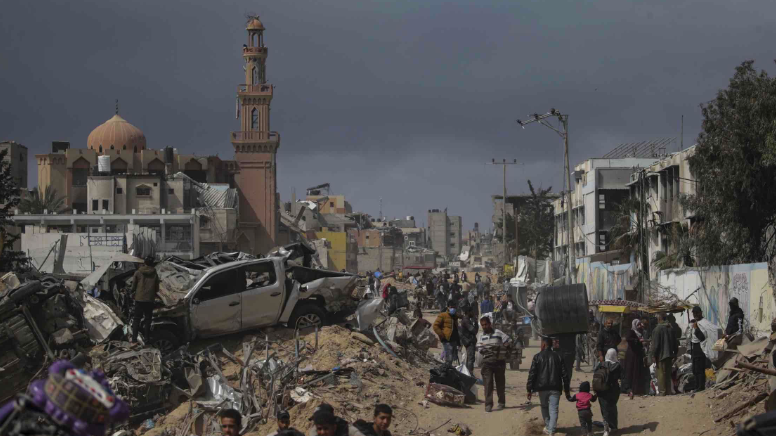 فلسطينيون محاطون بأنقاض المباني المدمرة في أعقاب العملية العسكرية الإسرائيلية في خان يونس جنوب في 6 مارس/آذار 2024.