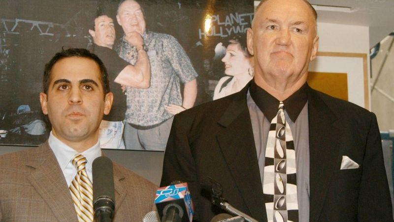 Chuck Wepner (dir.) anunciou a ação contra Stallone em entrevista coletiva em 2003, diante de uma imagem sua com o ator.