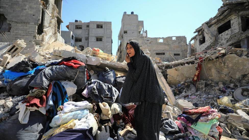Una mujer busca su pertenencias tras el retiro de tropas israelíes del distrito de Shejaiya en la Ciudad de Gaza. 
