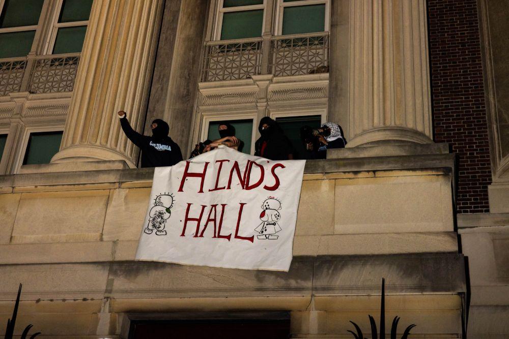 Manifestantes colocan un cartel que dice 
