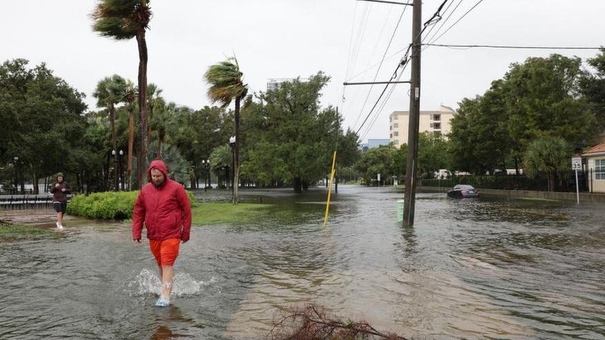 Kasırga geçtikten sonra Orlando'da yürüyen bir kent sakini.