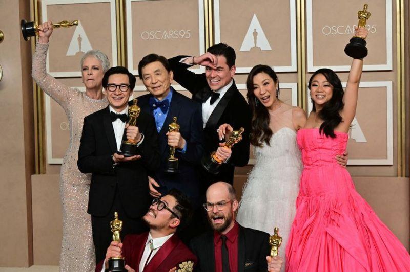 Elenco de filme posando junto para foto com estátuas do Oscar na mão