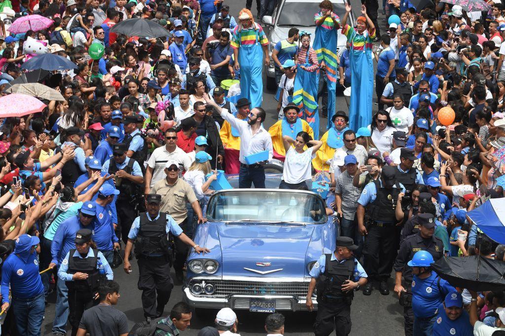 Nayib Bukele, entonces alcalde de la capital San Salvador, arroja dulces desde un coche durante la celebración del Día del Divino Salvador del Mundo, patrón de la ciudad, el 1 de agosto de 2017.