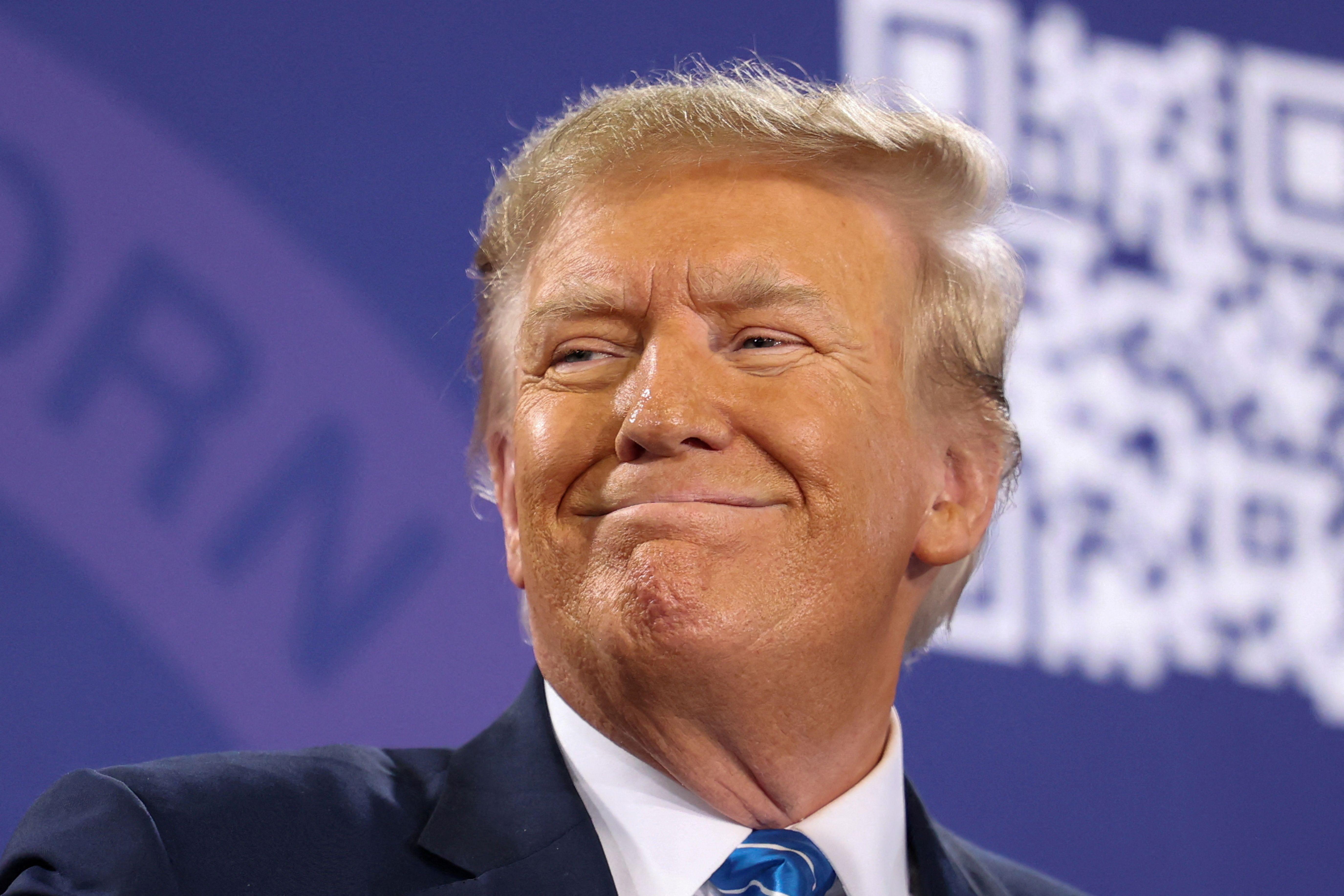 Donald Trump sorrindo e olhando para o lado