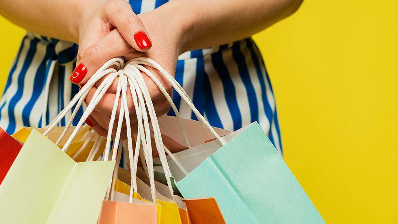 Manos de una mujer sosteniendo muchas bolsas de compras 