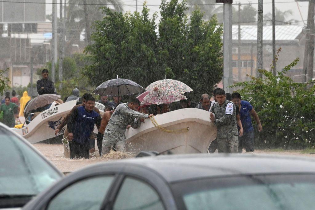 Members of the national guard and police officers help people on a flooded street after Hurricane John in Acapulco, Mexico, on September 26, 2024. 