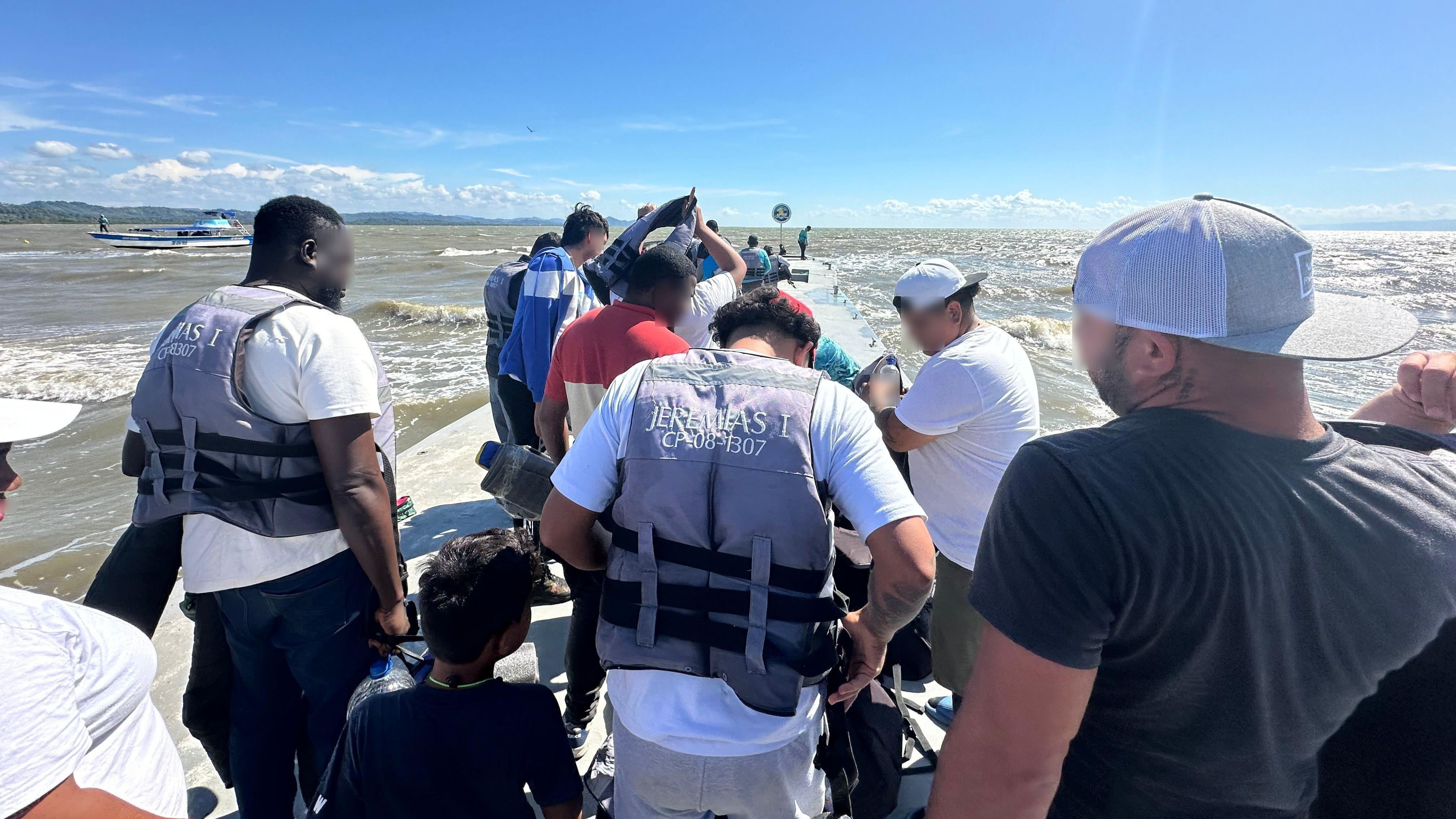 Grupo de turistas y migrantes en el muelle de Necoclí. 