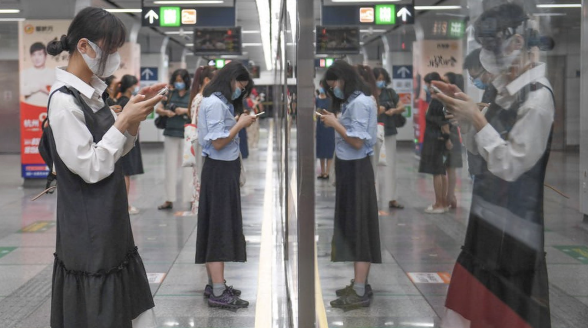 Passengers looking at their smartphones in a subway station in China