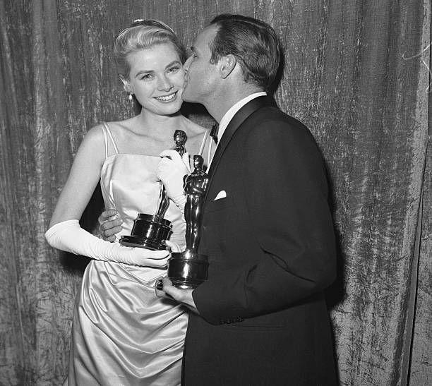 مارلون براندو يقبل غريس كيلي بعد حصولهما على جائزة الأوسكار لأفضل ممثل وممثلة في عام 1954