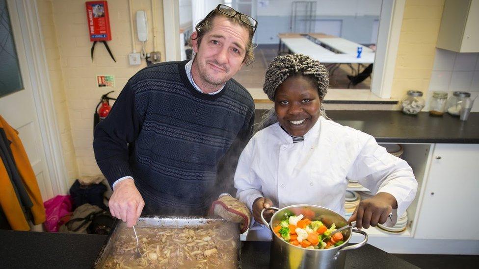Voluntários cozinhando em um centro comunitário via Timebanking UK