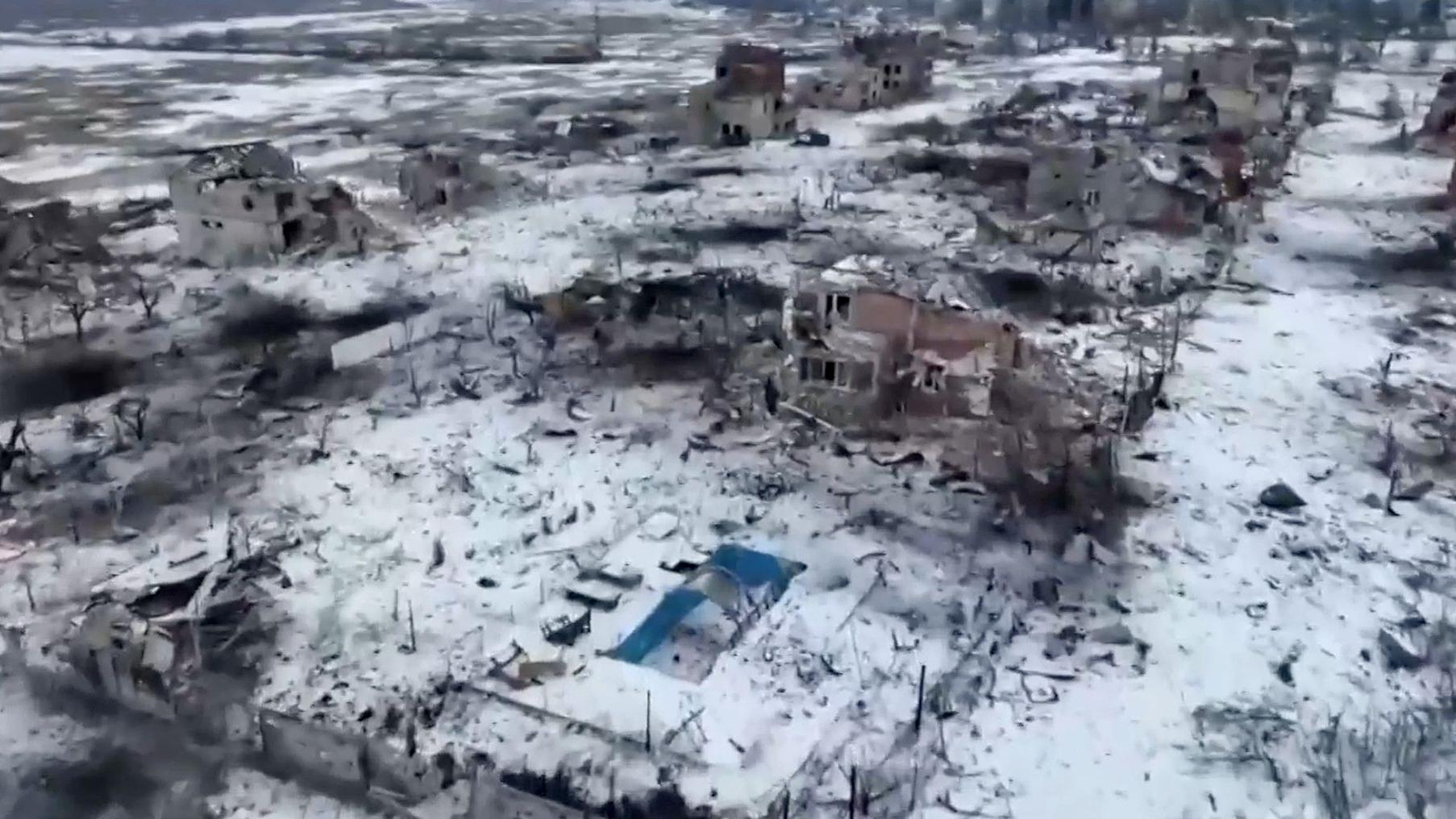 Vista de cima, a casa da Marina e a piscina azul vazia - há neve no chão e outras casas danificadas próximas