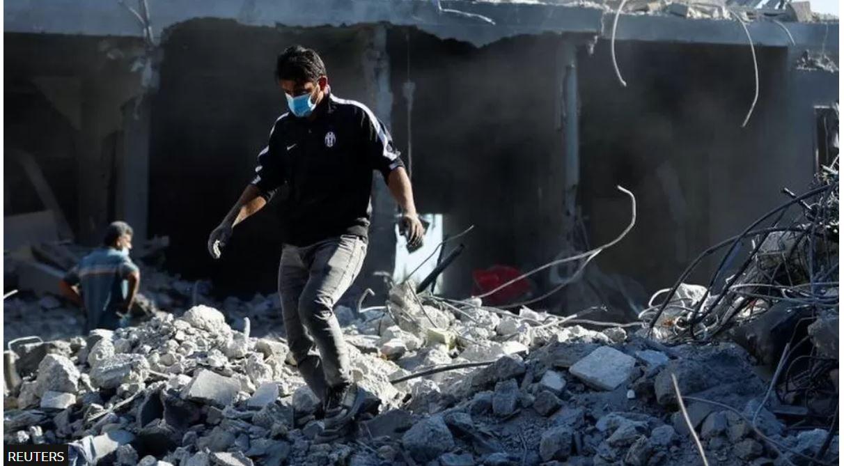فلسطيني يتفقد أنقاض منزل تهدم بفعل القصف الإسرائيلي على قطاع غزة