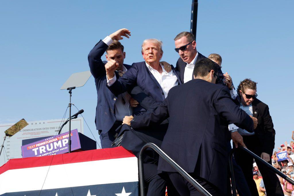  El candidato republicano a la presidencia de EE.UU., el expresidente Donald Trump, es sacado a toda prisa del escenario durante un mitin el 13 de julio de 2024 en Butler, Pensilvania.