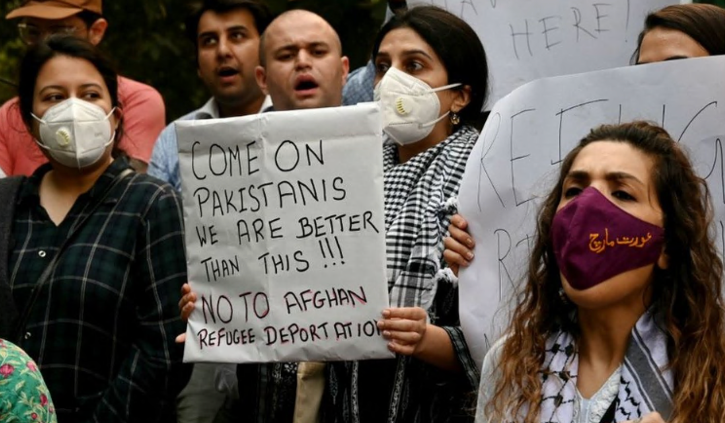 People hold placards as they protest against the deportation of Afghans from Pakistan