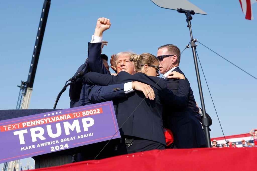  El candidato republicano a la presidencia de EE.UU., el expresidente Donald Trump, es sacado a toda prisa del escenario durante un mitin el 13 de julio de 2024 en Butler, Pensilvania.