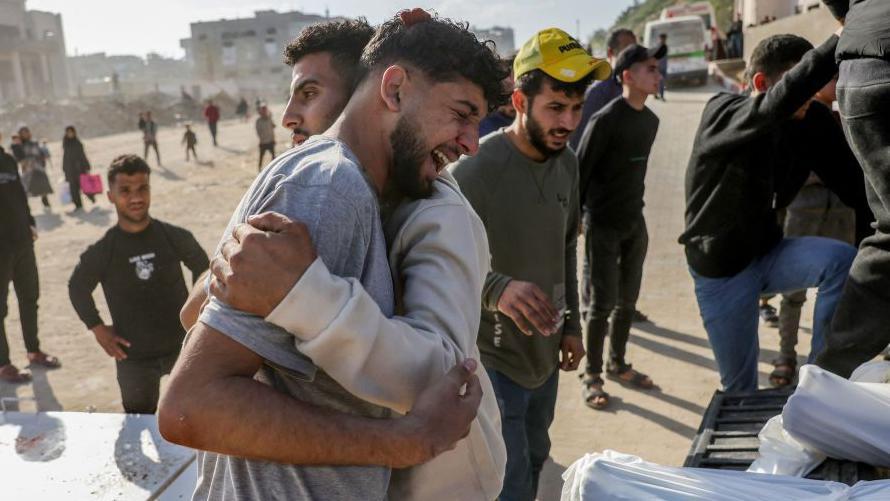 Dos hombres llorando por un ser querido muerto