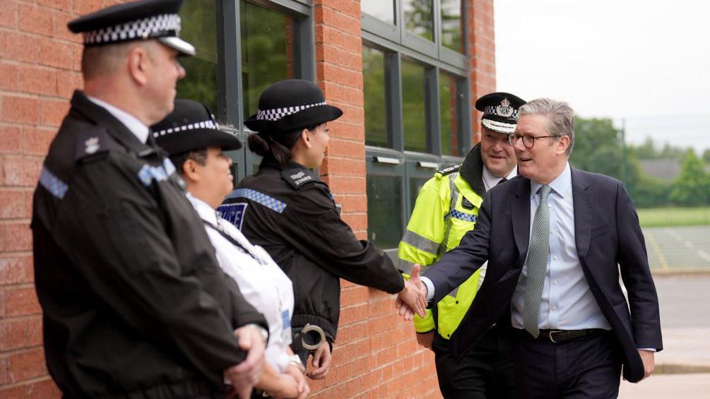 El primer ministro británico, Keir Starmer, saluda a policías en las Tierras Medias Occidentales de Inglaterra