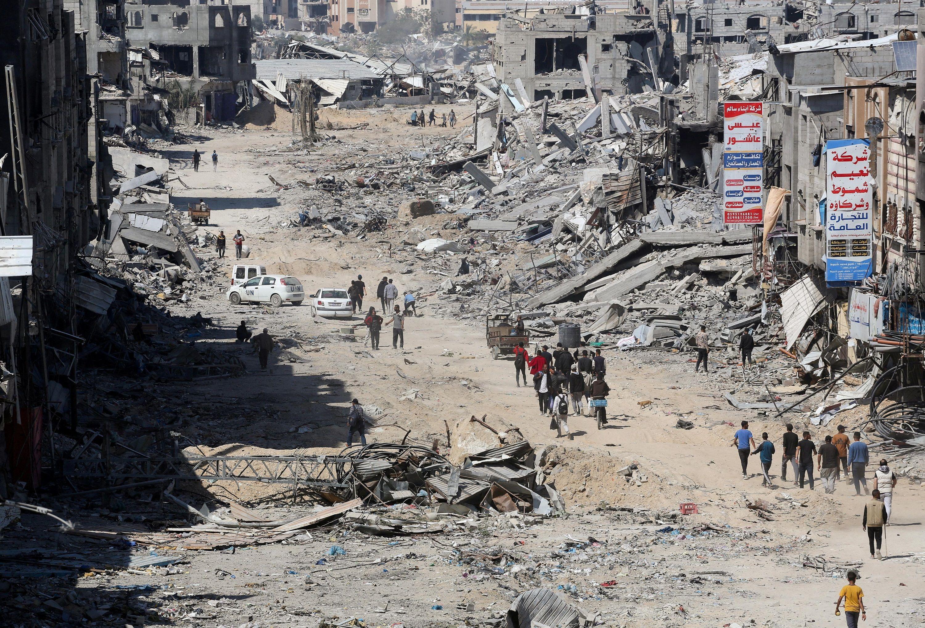 فلسطينيون يتفقدون المباني السكنية المدمرة، بعد أن سحب الجيش الإسرائيلي معظم قواته البرية من جنوب قطاع غزة، وسط الصراع المستمر بين إسرائيل وحماس، في خان يونس بجنوب قطاع غزة، 7 أبريل، 2024.