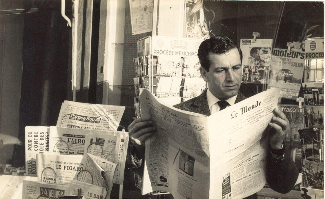 Fernando Sabino lendo o jornal Le Monde em frente a jornaleiro