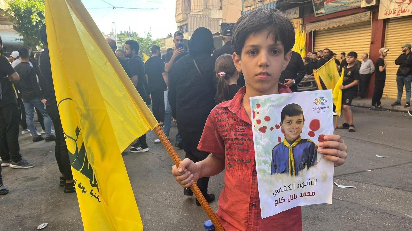 A boy with a flag and a sign