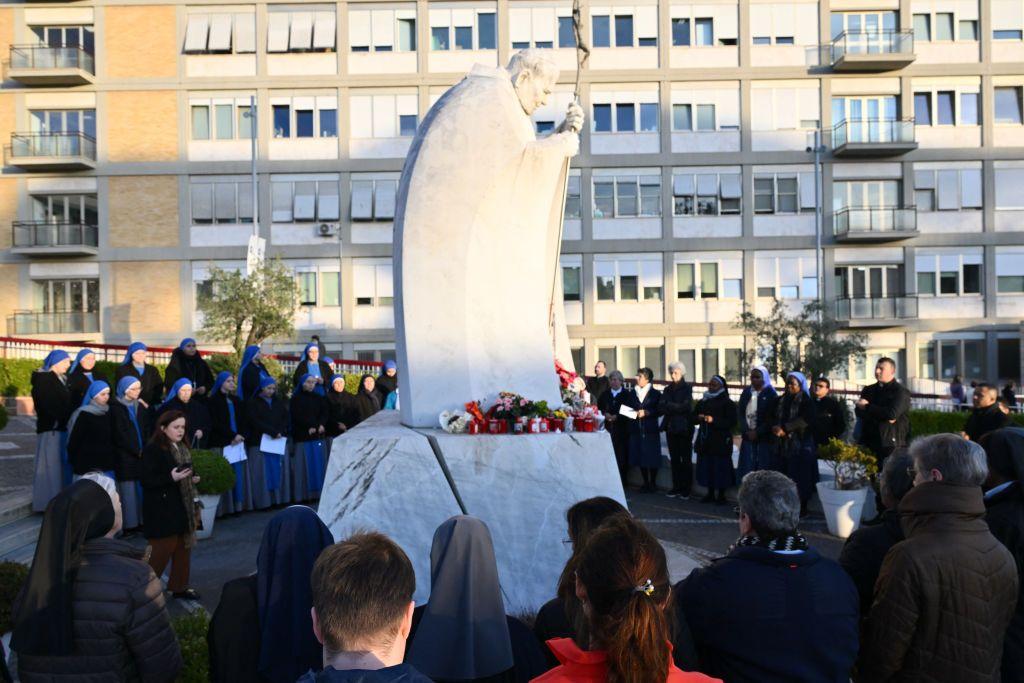 Monjas y fieles ante la estatua de Juan Pablo II en el hospital Gemelli.