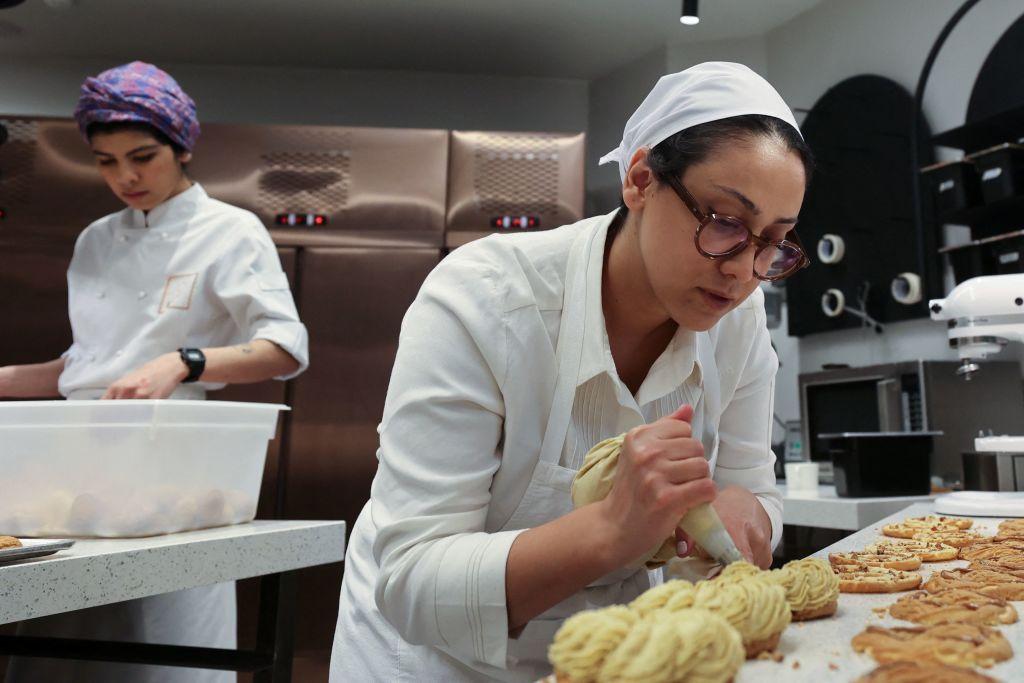 Iranian pastry chef Shahrzad Shokouhivand (right) works in the kitchen of her luxury pastry company in Tehran