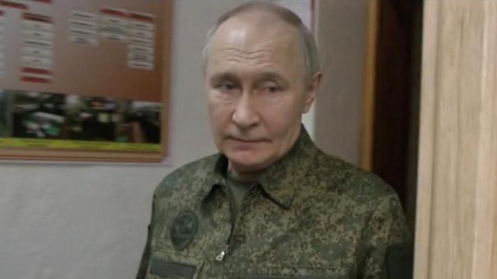 Putin caminhando em corredor, com olhar sério