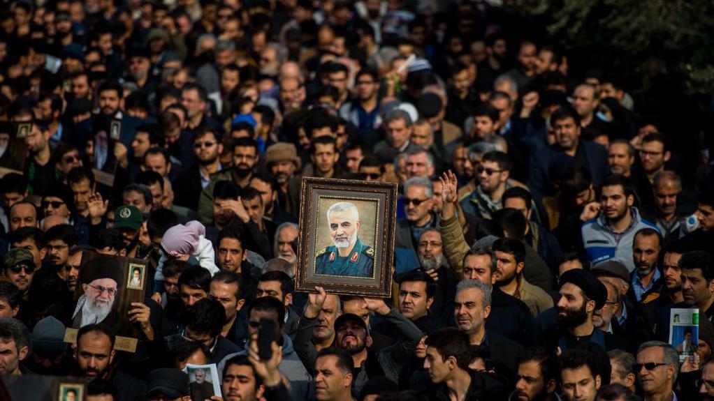 متظاهرون في طهران يرفعون صورة قاسم سليماني الذي قتل في غارة جوية أمريكية استهدفت موكبه في محيط مطار بغداد في الثالث من يناير/كانون الثاني 2020