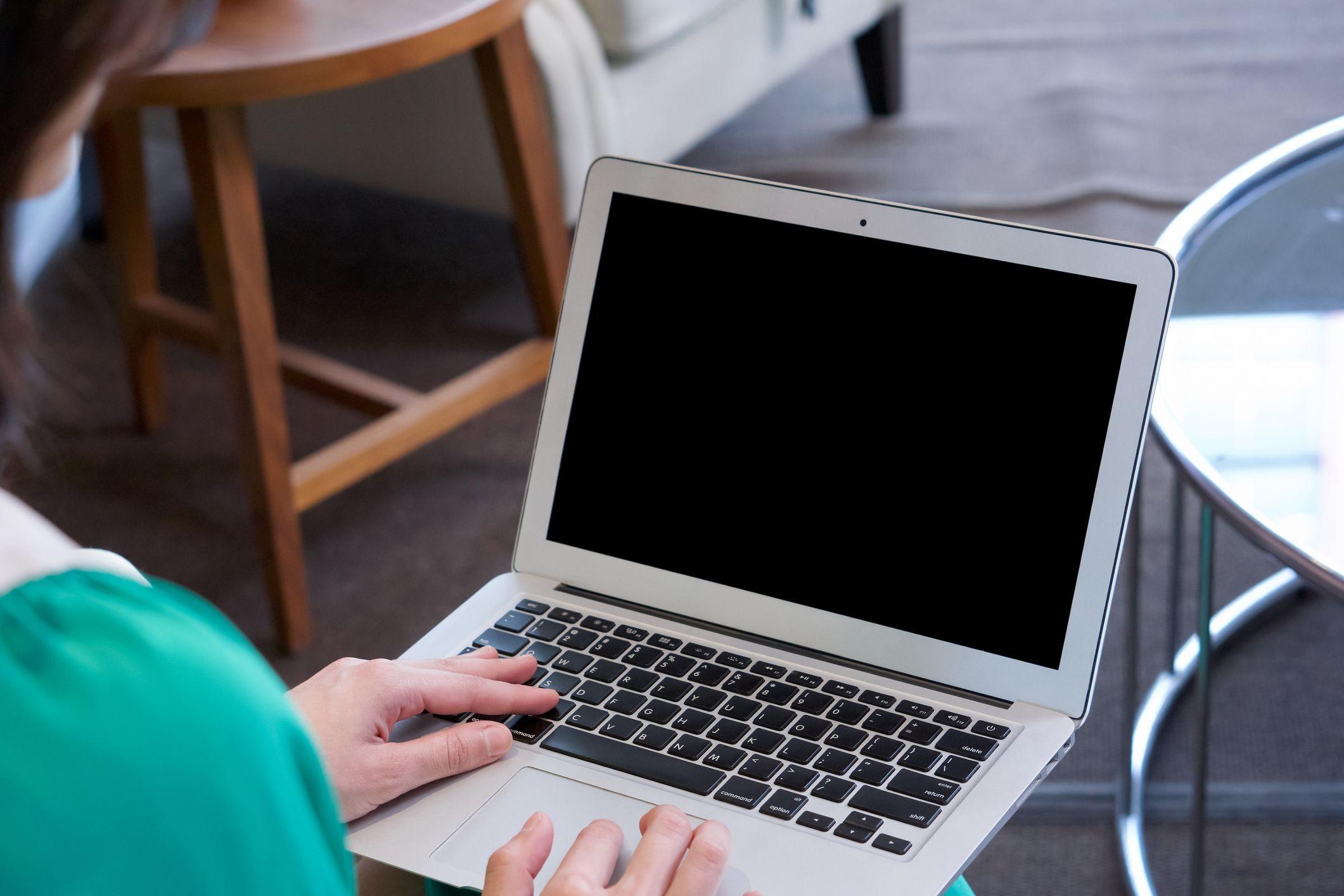 Uma mulher usando um computador cuja tela está escura
