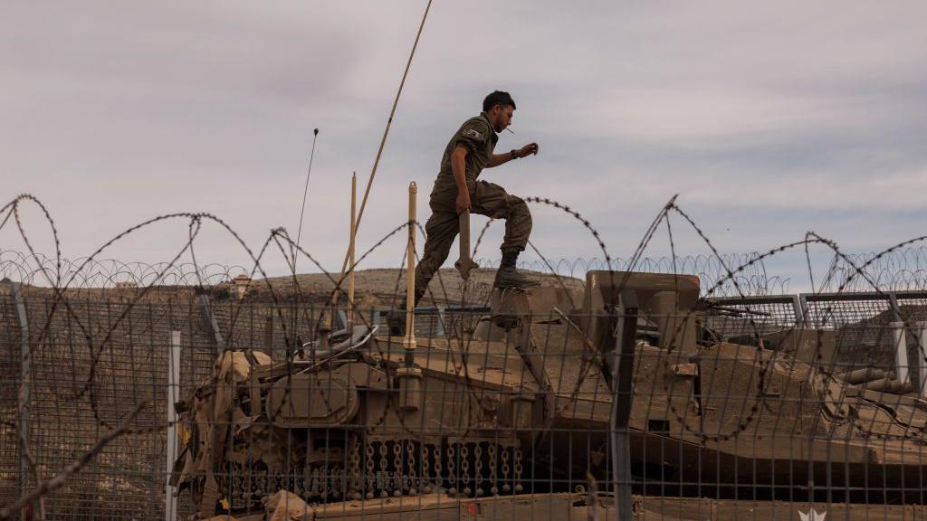 Seorang tentara Israel di atas tank di pagar perbatasan di sepanjang zona penyangga dengan Suriah terlihat dari Dataran Tinggi Golan, pada Rabu, 11 Desember 2024.