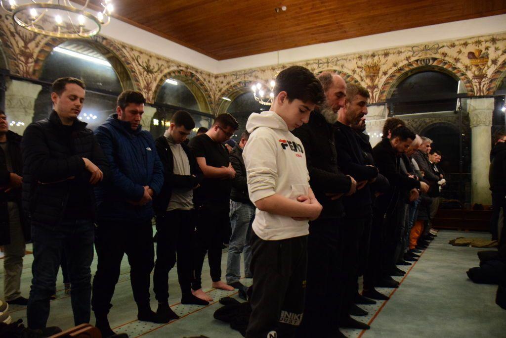 Homens rezando na mesquita, em pé e alinhados 