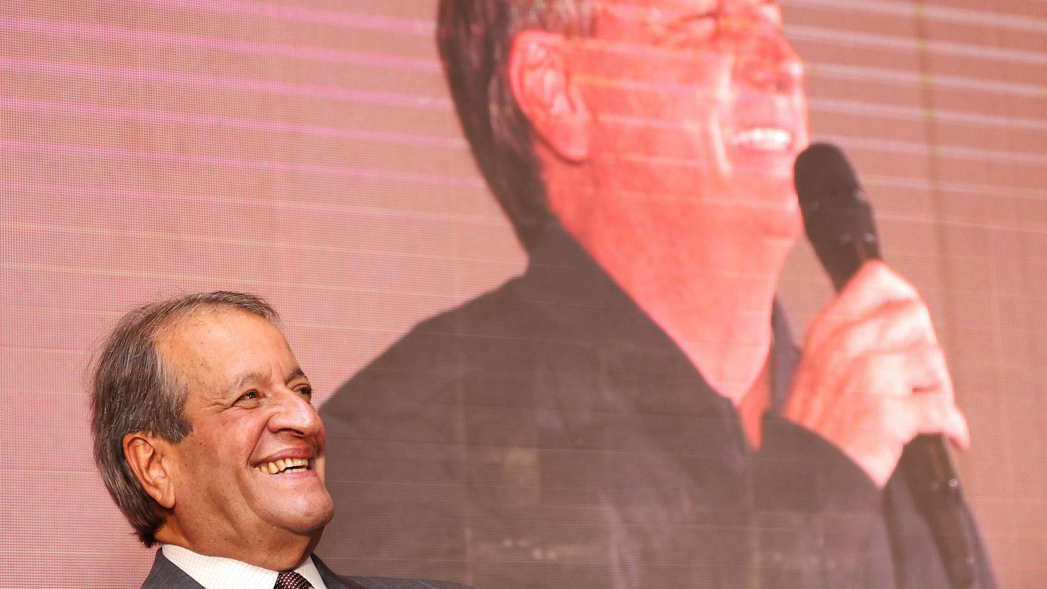 Valdemar Costa Neto, presidente do PL, em evento em frente a um telão em que aparece Bolsonaro