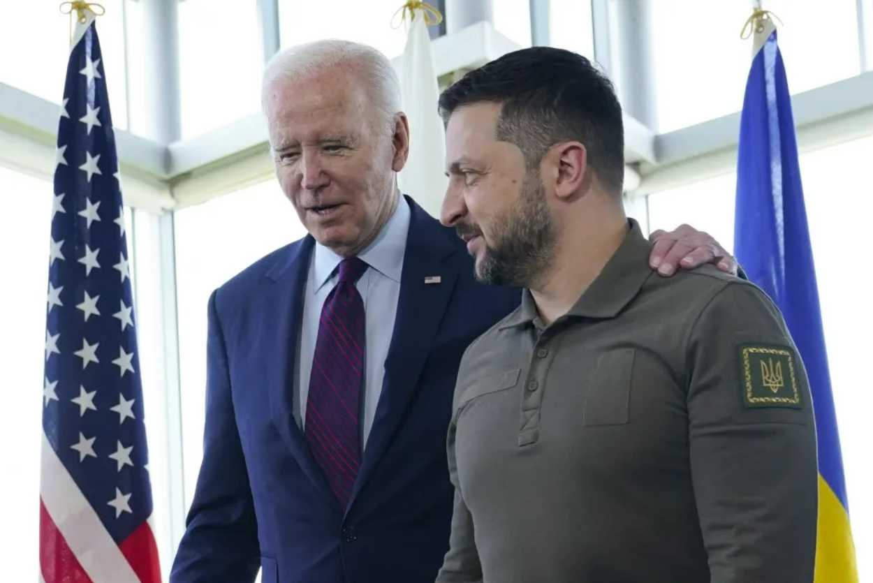 Biden e Zelensky abraçados e sorrindo contidamente