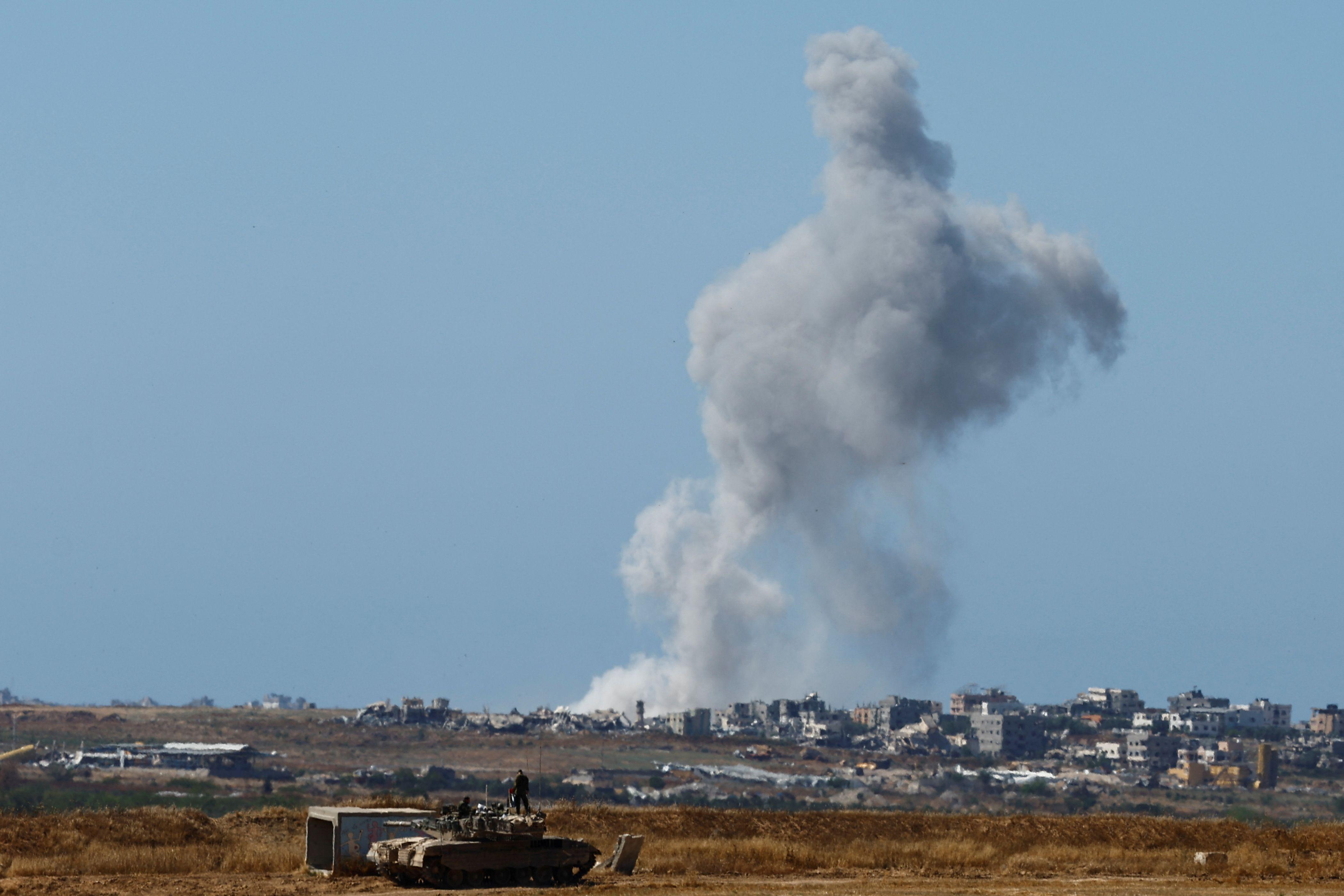 دبابة إسرائيلية تتخذ موقعها مع تصاعد الدخان في غزة