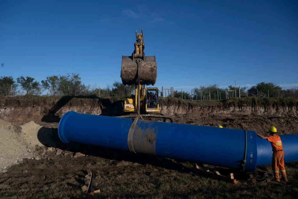 Trabajadores manipulan con maquinaria tuberías que llevarán agua de un río cercano a la cuenca que abastece a Montevideo y zonas cercanas.