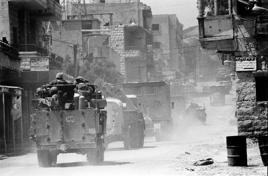 Soldados israelenses em veículos blindados passando por casas em um vilarejo no Vale do Bekaa durante a invasão israelense do Líbano em junho de 1982.