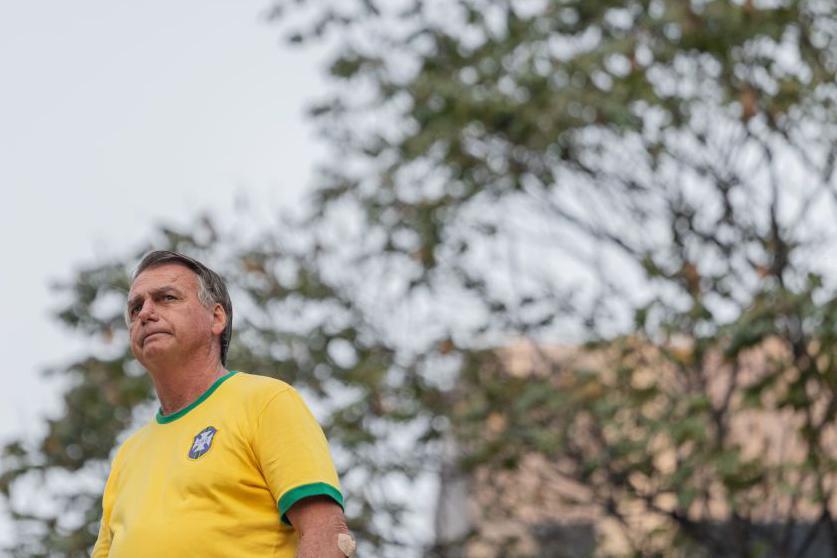 Bolsonaro, com camiseta do Brasil, olha para o lado 