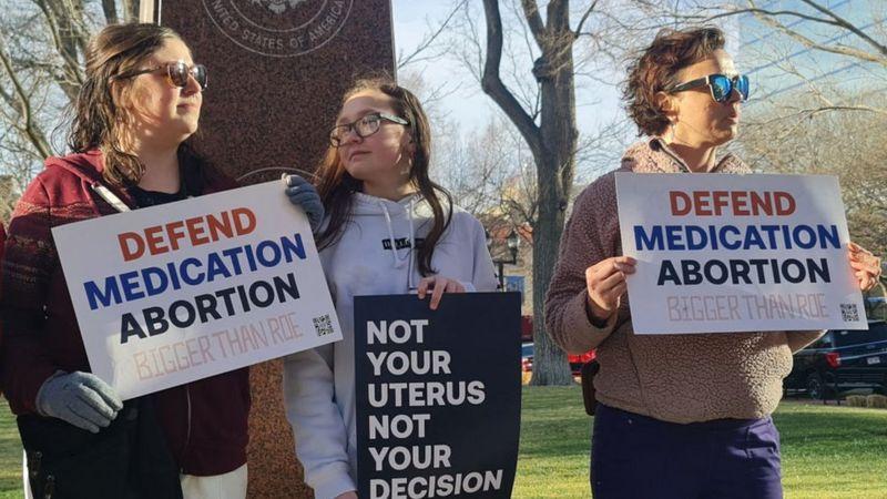 Ativistas seguram cartazes em defesa ao direito de abortar nos EUA