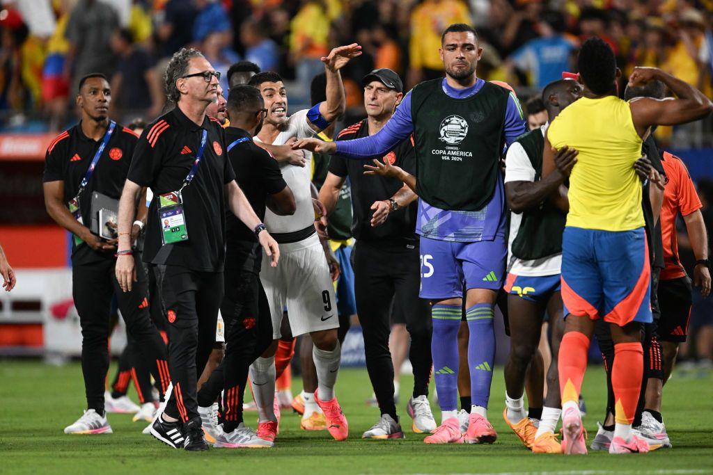 Técnicos y jugadores en el campo de fútbol tras el partido entre Colombia y Uruguay