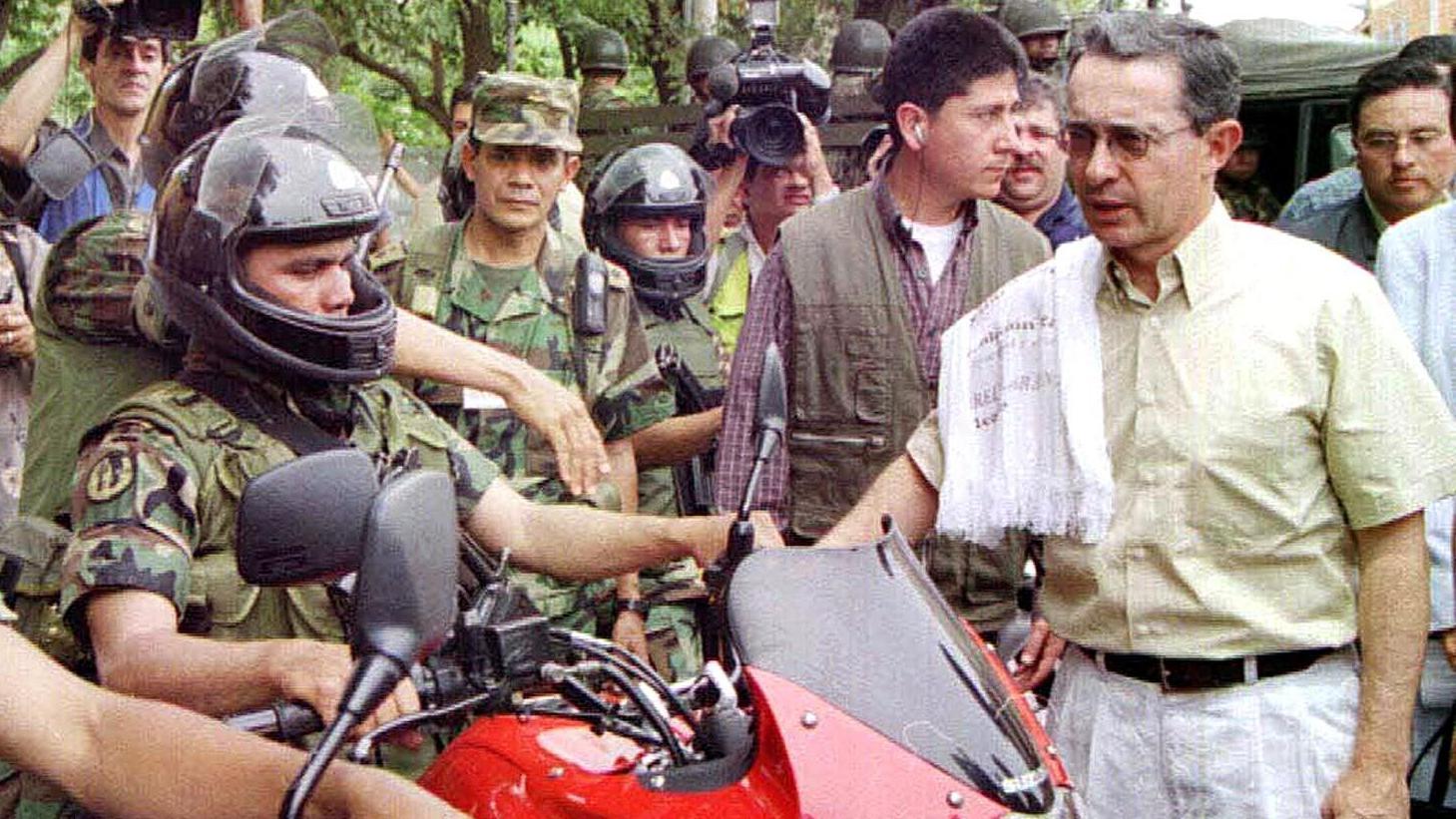 Álvaro Uribe saluda a soldados del ejército de Colombia en 2002. 