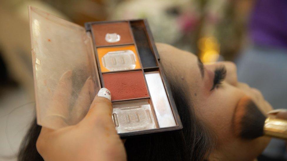 Una mujer recibe un servicio de maquillaje en Afganistán